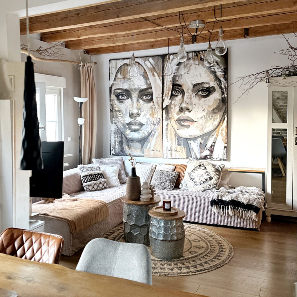 Zweiteiliges Kunstwerk mit zwei Frauengesichtern über Boho-Sofa im Wohnzimmer