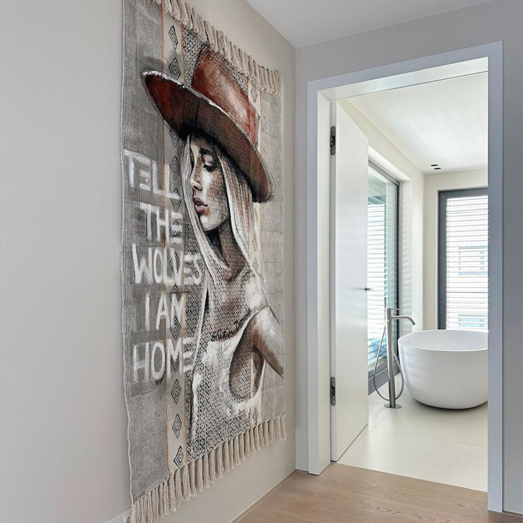 Textilkunstwerk „Tell the wolves I am home“ mit Frauenporträt neben Badezimmer