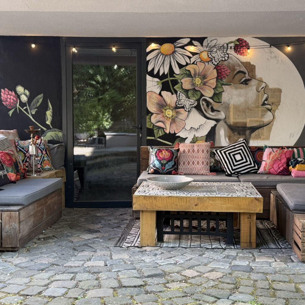 Blumen-Wandgemälde mit Frauenprofil auf dunkler Terrassenwand