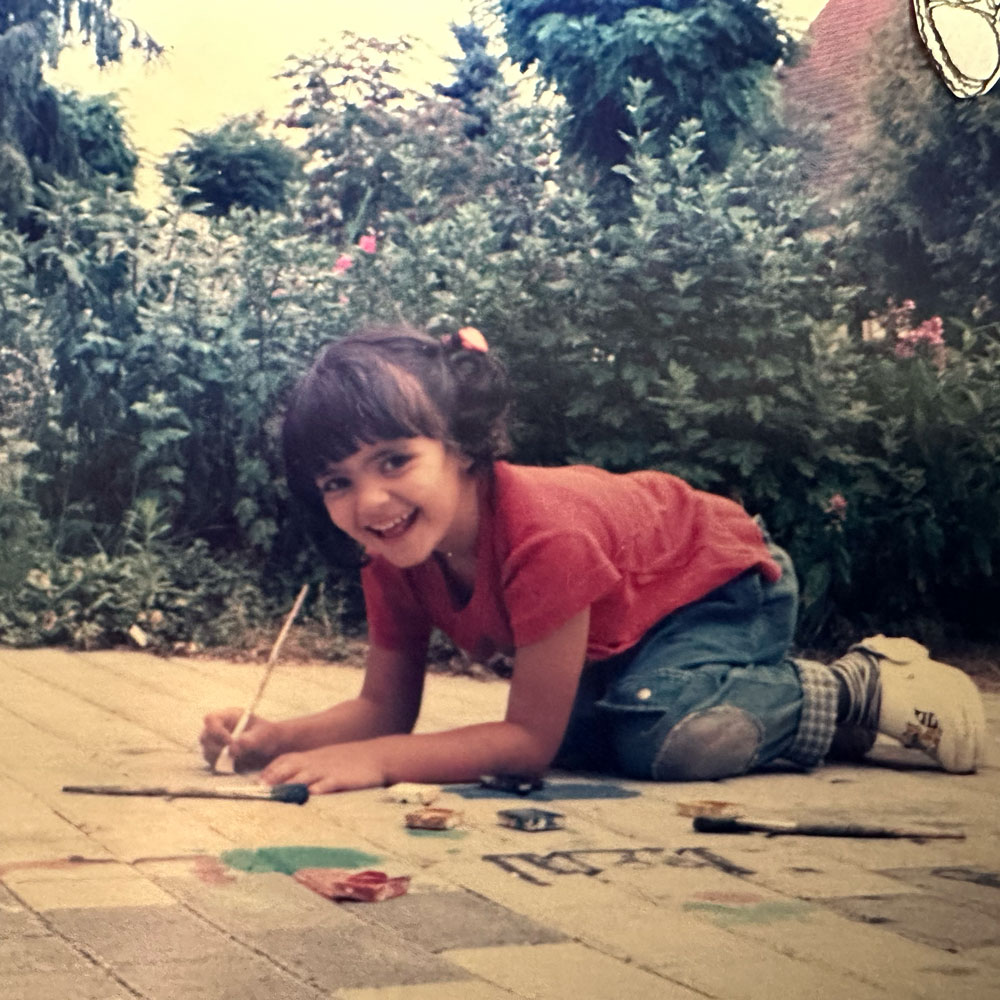 Shirin Donia as a little child, painting on the floor